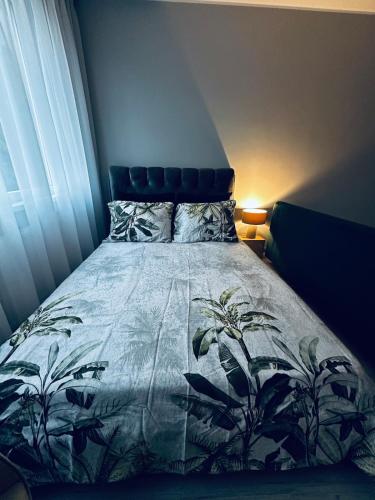 ein Schlafzimmer mit einem Bett mit blauem Kopfteil in der Unterkunft Apartamentai Smaragdinis vėjas in Šilutė