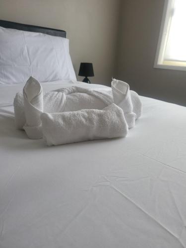 a white bed with white towels on it at A slice of Melbourne! Room 1 in Craigieburn