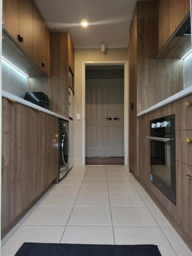 a kitchen with a door and a tile floor at A slice of Melbourne! Room 1 in Craigieburn