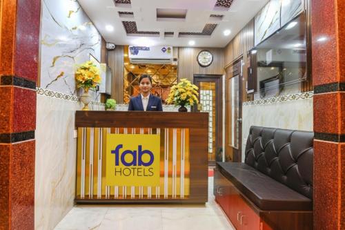 a man standing behind a counter in a hotel lobby at FabHotel MN International - Nr Park Circus in Kolkata