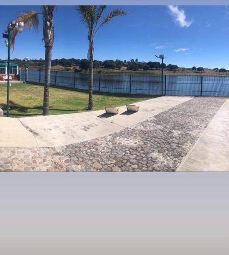 two photographs of a park with palm trees and water at SUITES HOTEL natural Africam Safari in Santo Tomás Chautla