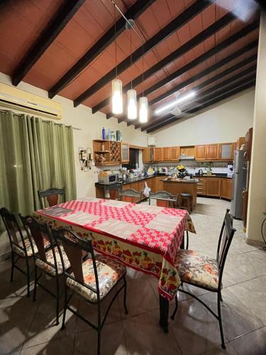 a dining room with a table and chairs and a kitchen at Quinta LA PALOMA in San Lorenzo