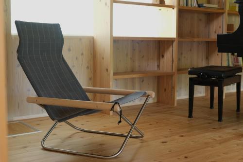 una mecedora en una habitación con un piano en Lotus Retreat ロータスリトリート 高知空港から車で35分 山のふもとの一棟貸しコテージ, en Kami