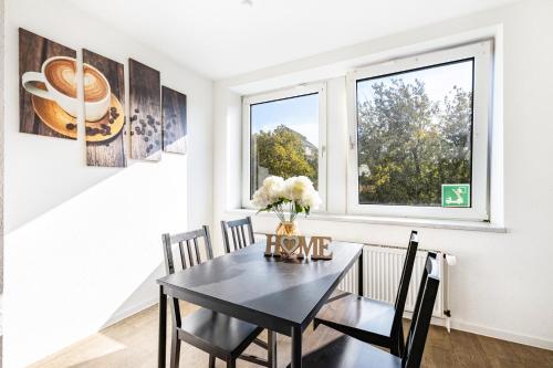 a dining room with a black table and a window at Key2Komfort in Duisburg