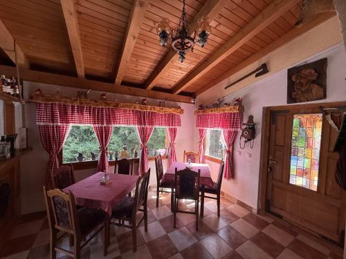 a dining room with tables and chairs and red curtains at Resort Zevs Komovi in Trešnjevik
