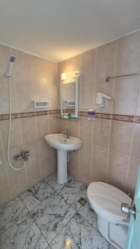 a bathroom with a toilet and a sink at Hikmethan Otel in Kusadası