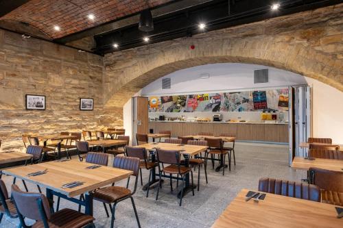 an empty restaurant with wooden tables and chairs at Best Western Plus The Quays Hotel Sheffield in Sheffield