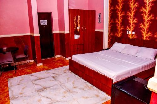 a bedroom with a bed in a room with pink walls at 5 Star Villa Hotel in Accra