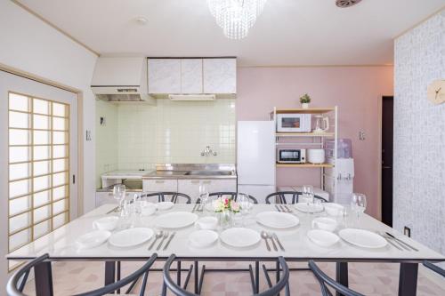 een eetkamer met een witte tafel en stoelen bij TDR車9分 3BR 5Bed 夢の続きを楽しめる宿 -TAMU-LAND Kasai- in Tokyo