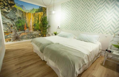 une chambre avec un grand lit avec un tableau au mur dans l'établissement aridane loft, à Los Llanos de Aridane