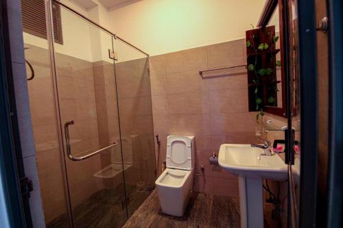 a bathroom with a shower and a toilet and a sink at Harbour View Resort in Ambalangoda