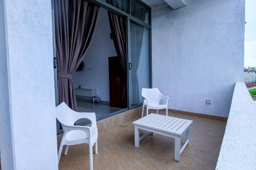 a balcony with two chairs and a table and a window at Harbour View Resort in Ambalangoda