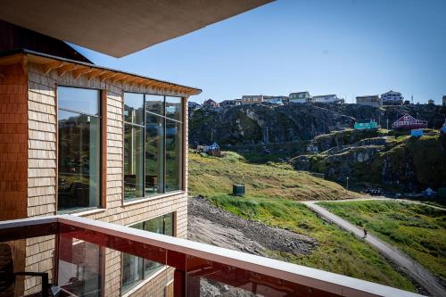 a balcony of a house with a view of a mountain at HOTEL SØMA Sisimiut in Sisimiut