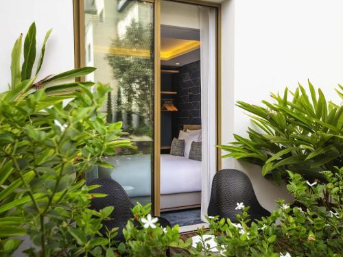 a balcony with two chairs and a bed in a room at Aparthotel Adagio Premium Casablanca City Center in Casablanca