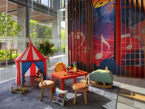 a childrens play area with a tent and chairs at ibis Styles Bangkok Ratchada in Bangkok