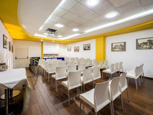 a room with white chairs and tables and yellow walls at Ibis Styles Palermo Cristal in Palermo