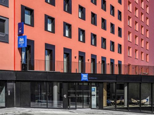 an orange building with a balcony in front of it at ibis budget Saint-Étienne Centre Gare Châteaucreux in Saint-Étienne