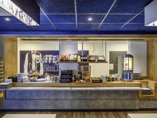 a store front with a counter with food on it at ibis budget Saint-Étienne Centre Gare Châteaucreux in Saint-Étienne