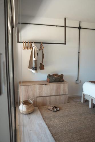 a bedroom with a bed and a table with shoes at Bodegas y Viñedos Balcarce in Balcarce