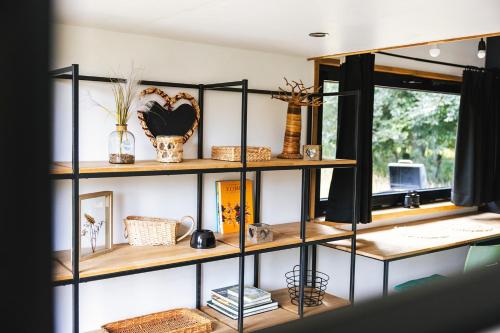 a shelf with vases and baskets on it at Tiny House Natuur & cultuur nabij Brugge! in Beernem