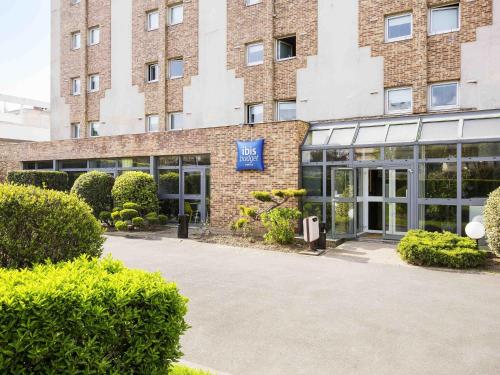 a brick building with a blue sign in front of it at Ibis Budget Fresnes Orly in Fresnes