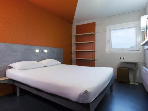 a large white bed in a room with a window at Ibis Budget Fresnes Orly in Fresnes