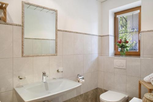 a bathroom with a sink and a toilet and a window at Zillertalblick in Zell am Ziller