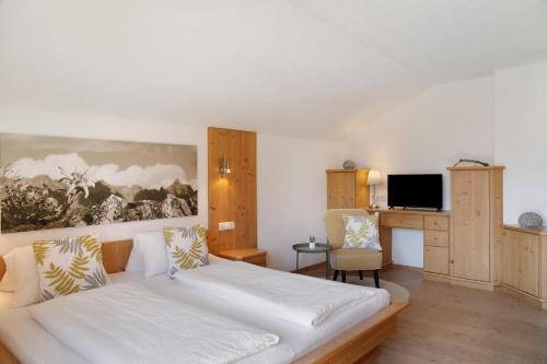 a hotel room with a bed and a desk at Zillertalblick in Zell am Ziller