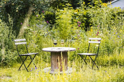 a table with two chairs and two glasses of wine at Tiny House Natuur & cultuur nabij Brugge! in Beernem