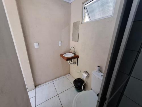 a small bathroom with a toilet and a sink at Cabanas V13, segundo maior viaduto do mundo! Sem ar in Vespasiano Corrêa
