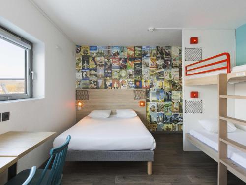 a bedroom with a bed and a wall with pictures at hotelF1 Igny Massy TGV in Igny