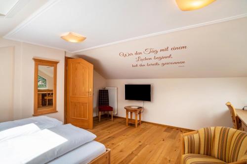 a bedroom with a bed and a tv on the wall at Wein- und Klimahotel Bergfriedel in Bühlertal