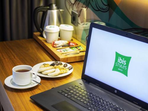 a laptop computer sitting on a desk with a cup of coffee at Ibis Styles Istanbul Atasehir in Istanbul