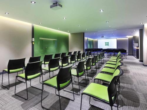 a waiting room with green chairs and a stage at Ibis Styles Istanbul Atasehir in Istanbul