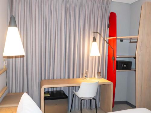 a bedroom with a desk and a red surfboard at ibis Cucuta in Cúcuta