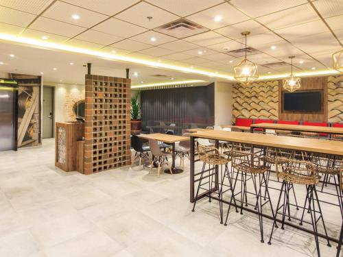 a restaurant with tables and chairs and a bar at ibis Cucuta in Cúcuta