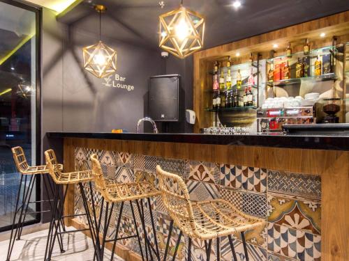 a bar with wicker chairs sitting at a counter at ibis Cucuta in Cúcuta