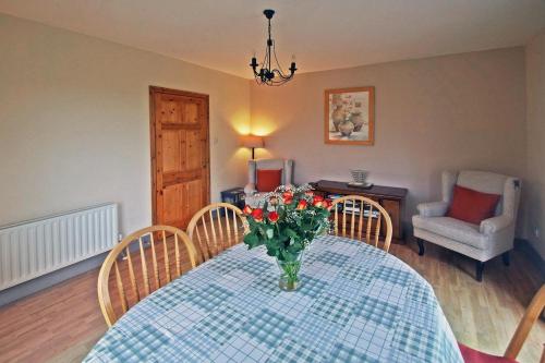a dining room table with a vase of flowers on it at 4 Bed in Clifden oc-i243 in Belleek
