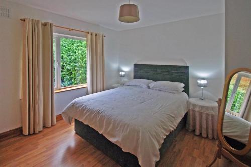 a bedroom with a large bed and two windows at 4 Bed in Clifden oc-i243 in Belleek