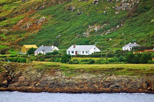 a group of houses on a hill next to the water at 4 Bed in Clifden oc-i243 in Belleek