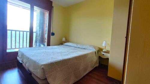 a bedroom with a bed and a large window at Apartamento en La Molina cerca de Pistas in La Molina