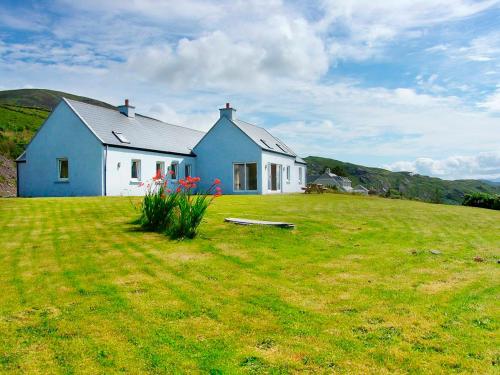 a blue and white house on a grass field at 4 Bed in Caherdaniel oc-ii15408 in Gortnaknilly