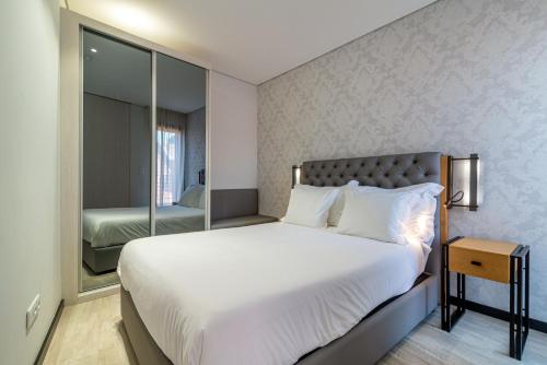 a bedroom with a large bed and a mirror at Smartr Porto Gaia in Vila Nova de Gaia