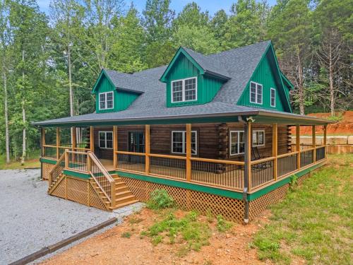 a large log cabin with a green roof at Log Cabin Sleeps 6 Woodsy Retreat! in Ashland City