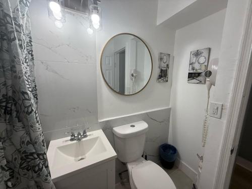 a bathroom with a toilet and a sink and a mirror at Modern cozy home with private patio - Sleeps 6 in Miami