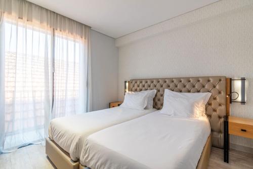 a bedroom with two beds and a large window at Smartr Porto Gaia in Vila Nova de Gaia