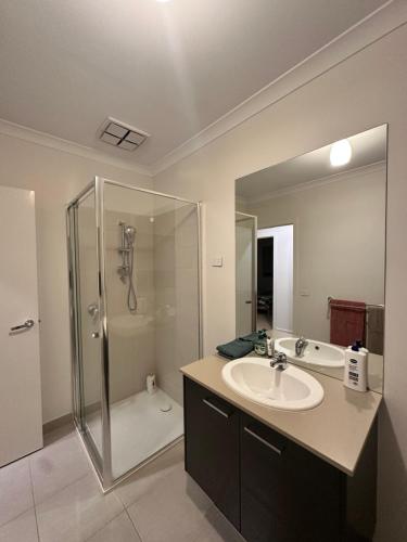 a bathroom with a sink and a shower at Stylish four bedroom family retreat in Saltwater Coast in Point Cook