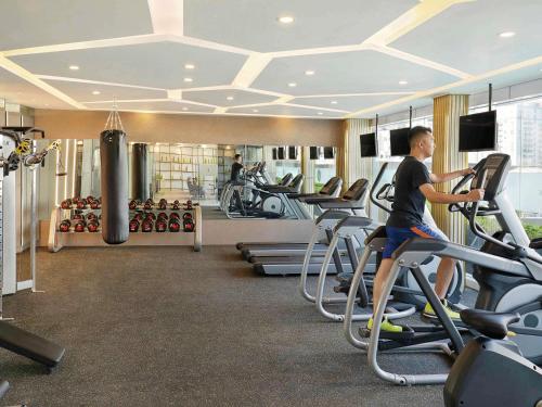 a man riding on a treadmill in a gym at Novotel Jakarta Cikini in Jakarta