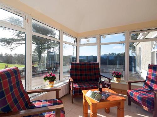a living room with two chairs and a table and windows at 4 Bed in Carrigaholt oc-ii15582 in Carrigaholt