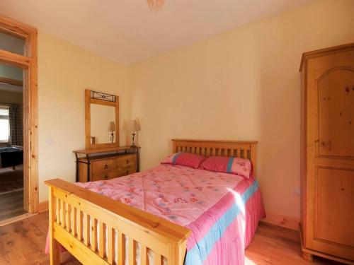 a bedroom with a bed and a dresser and a mirror at 4 Bed in Carrigaholt oc-ii15582 in Carrigaholt